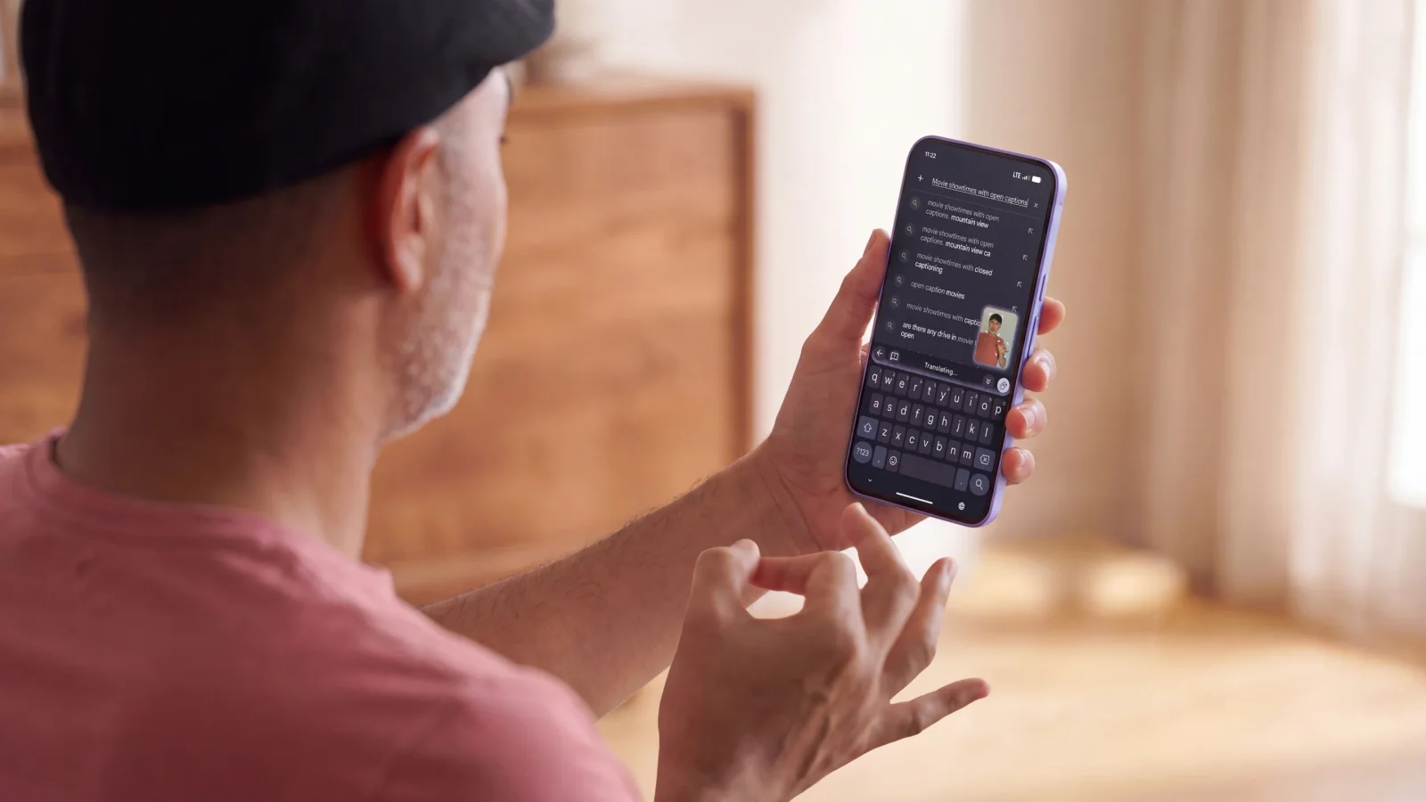 Close-up of a person using sign language with a smartphone displaying transcribed text.
